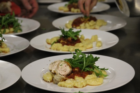 Hausgemachte Gnocchis mit italienischer Tomatensoße an Involtinis mit Schinken-Füllung und Rucola